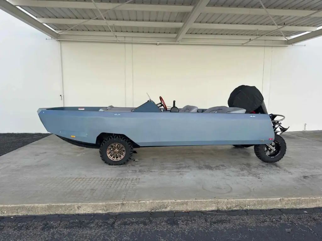 Side profile of Cam’s blue-gray WaterCar beneath a covered bay