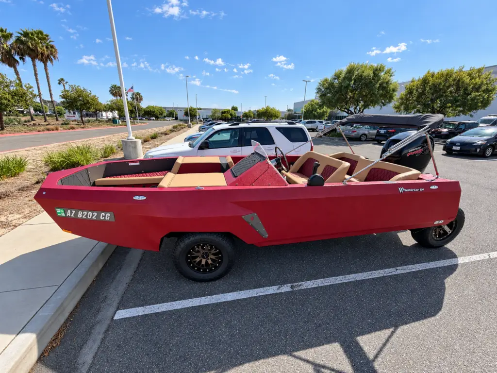 Burgundy WaterCar Signature on its wheels, with tan lounge seating and a matching canopy.