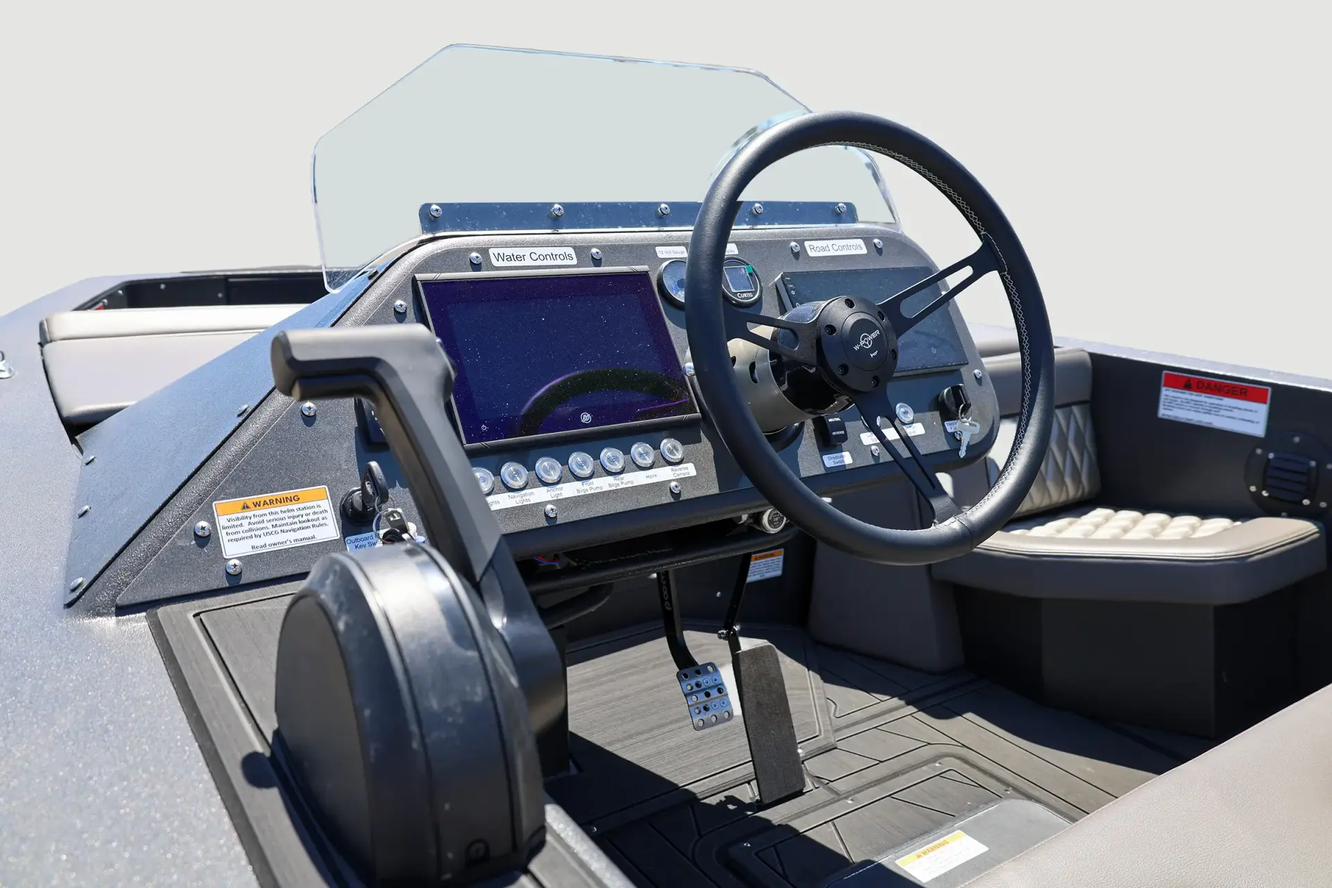 Graphite WaterCar cockpit with a black steering wheel, left throttle, displays and labeled controls.