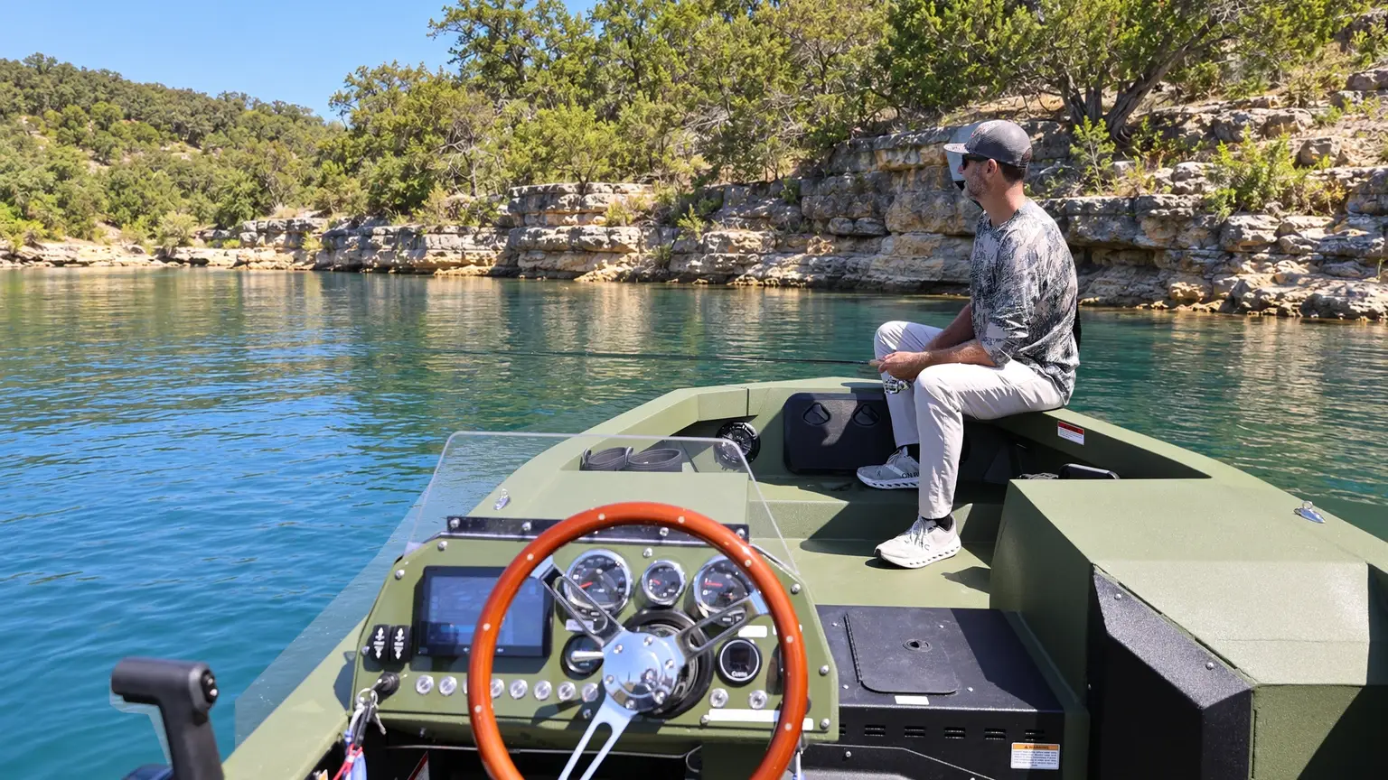 A view over the WaterCar Adventure helm toward an angler fishing from the open bow.